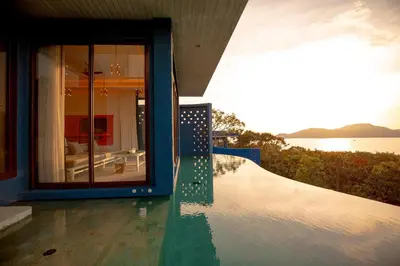 a house with a pool with a view of the water at Sri Panwa Phuket Luxury Pool Villa Hotel in Panwa Beach