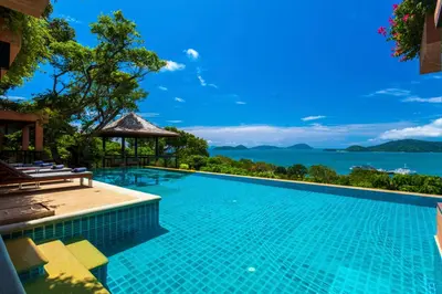 a swimming pool with a view of the water at Sri Panwa Phuket Luxury Pool Villa Hotel in Panwa Beach