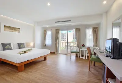a bedroom with a bed and a tv in a room at Palmyra Patong Resort Phuket - SHA Extra Plus in Patong Beach