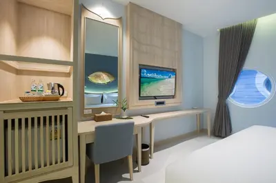 a bedroom with a desk with a computer and a bed at Beyond Patong in Patong Beach