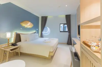 a hotel room with a bed and a table and a desk at Beyond Patong in Patong Beach