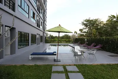 a patio with a table and an umbrella next to a pool at S4 Nai Yang Beach - Near Phuket Airport in Nai Yang Beach