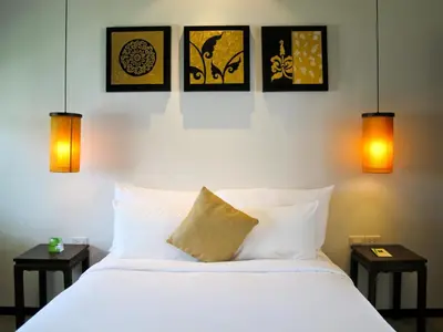 a bedroom with a white bed with four pictures on the wall at Two Villas HOLIDAY - Oxygen Style Bangtao Beach, Phuket in Bang Tao Beach