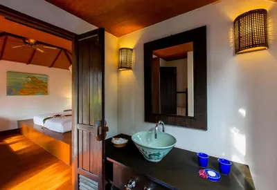 a bathroom with a sink and a bed at Elixir Resort Koh Yao Yai - SHA Plus in Ko Yao Yai