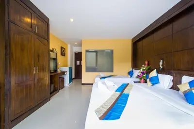a hotel room with two beds and a flat screen tv at Thai Siam in Patong Beach
