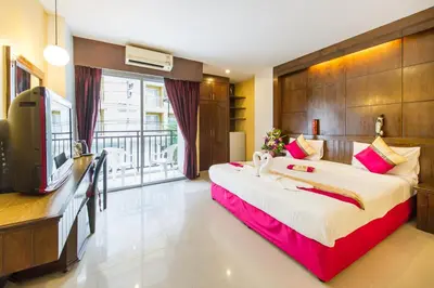a hotel room with a large bed and a television at Thai Siam in Patong Beach