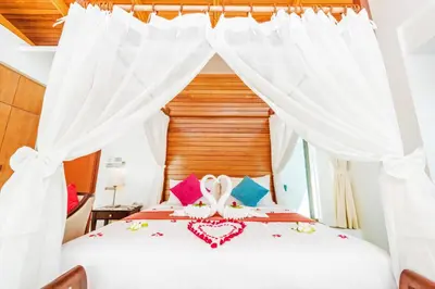 a bedroom with a bed with white drapes at Wyndham Sea Pearl Resort, Phuket in Patong Beach