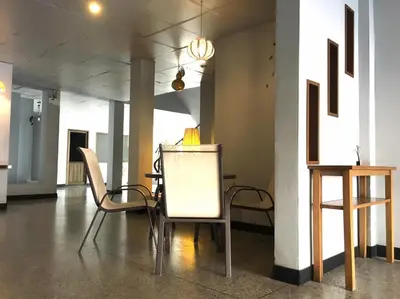 a room with two chairs and a table in it at Summer Hotel in Phuket Town