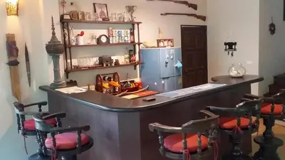 a bar in a room with chairs and a refrigerator at KhaoTong Villa at Melina's in Tha Lane Bay