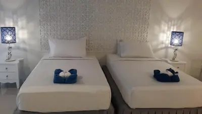 two beds with blue bow ties on them in a bedroom at PP Blue Sky Resort-SHA Plus in Phi Phi Don