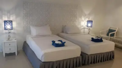 two beds in a room with two blue towels at PP Blue Sky Resort-SHA Plus in Phi Phi Don