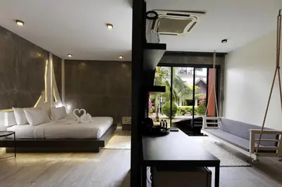 a bedroom with a bed and a living room at Phi Phi Andaman Legacy Resort in Phi Phi Don
