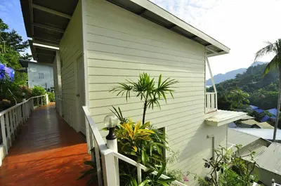 a white house with a porch with plants on it at Uphill Cottage in Phi Phi Don