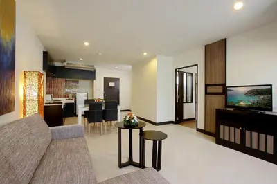 a living room with a couch and a kitchen at Kata Sea Breeze Resort - SHA Plus in Kata Beach