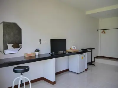 a kitchen with a counter with a tv and a stool at Marisa Garden Bungalow in Bang Tao Beach