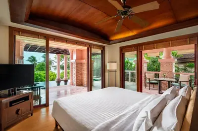 a bedroom with a bed and a flat screen tv at Centara Grand Beach Resort Phuket in Karon Beach