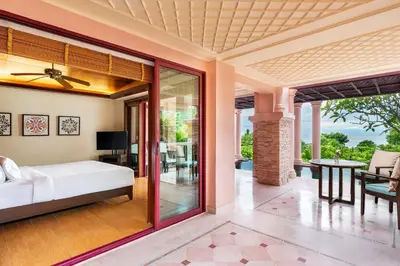 a living room with a bed and a patio at Centara Grand Beach Resort Phuket in Karon Beach