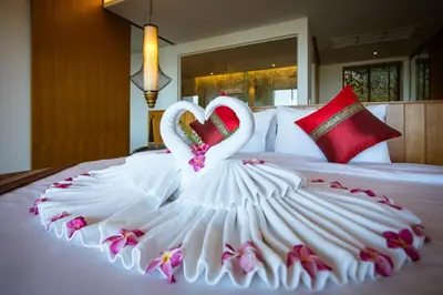 two swans in a dress on a bed at Chalong Chalet Resort in Chalong
