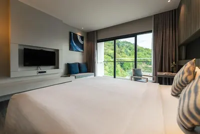 a large bedroom with a large bed and a large window at Hotel IKON Phuket - SHA Extra Plus in Karon Beach