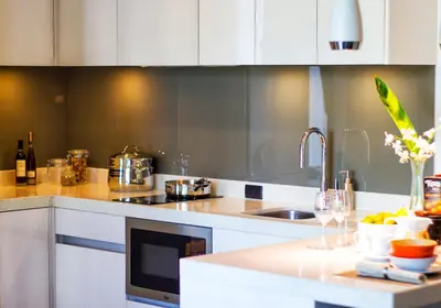 a kitchen with white cabinets and a sink and a counter at Oceanstone by Holy Cow, 2-BR, 60 m2, tree view in Bang Tao Beach