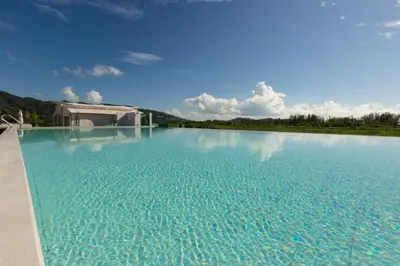 a large pool of blue water in front of a house at Oceanstone by Holy Cow, 2-BR, 60 m2, tree view in Bang Tao Beach