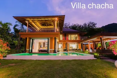 a villa with a swimming pool in front of a house at VILLA Chacha VILLA Coco RESORT APOLLONIA in Ko Yao Noi