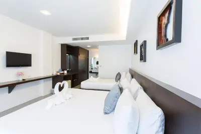 a white room with a bed and a tv at Phranang Place- SHA Extra in Ao Nang Beach