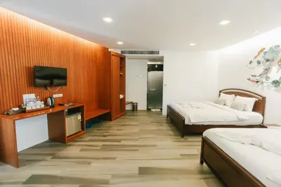 a hotel room with two beds and a television at Phranang Place- SHA Extra in Ao Nang Beach