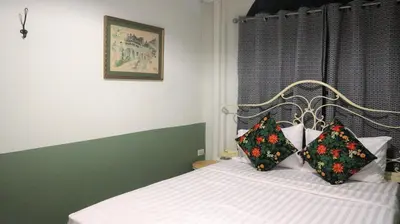 a bedroom with a bed with two pillows on it at The Neighbors Hostel in Phuket Town