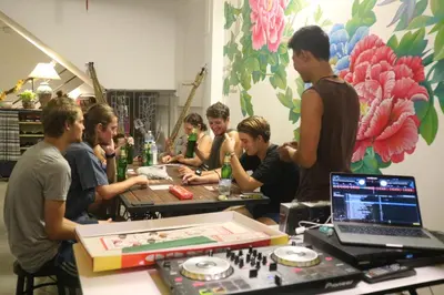 a group of people sitting around a table playing chess at The Neighbors Hostel in Phuket Town