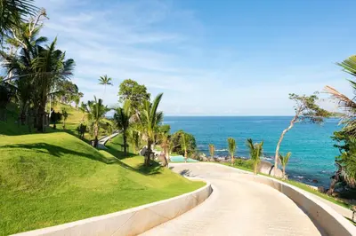 a winding road next to the ocean with palm trees at The Shore At Katathani - Adult Only - SHA Extra Plus in Kata Beach