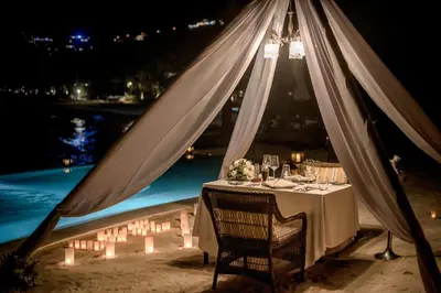 a dinner table with a chandelier and lights at The Shore At Katathani - Adult Only - SHA Extra Plus in Kata Beach