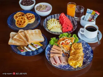 a table with four plates of breakfast foods and a cup of coffee at U Rip Resort Phi Phi Hotel in Phi Phi Don