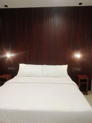 a bedroom with a white bed and red wall at Beach house by Rose massage in Nai Thon Beach