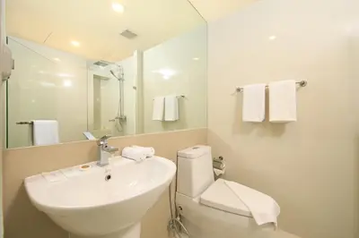 a bathroom with a sink and a toilet and a mirror at The Aristo by Holy Cow, 4-BR loft, 150 m2, pool view in Surin Beach