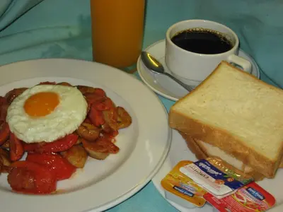 a plate of breakfast food with eggs and toast and a cup of coffee at PS Hotel Phuket Patong - SHA Plus in Patong Beach