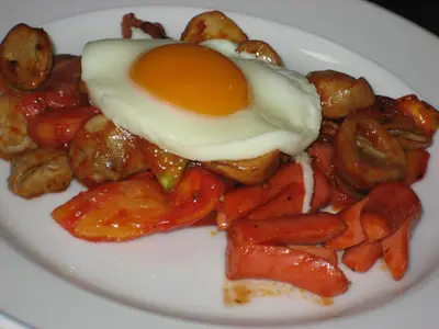 a plate of food with an egg and strawberries at PS Hotel Phuket Patong - SHA Plus in Patong Beach