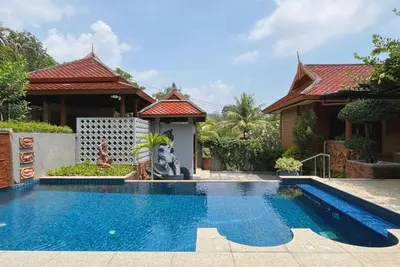 a house with a swimming pool in front of a house at Baleeyan in Thalang
