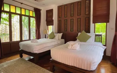 two beds in a room with windows at Baleeyan in Thalang