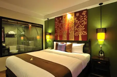 a bedroom with a large bed with green walls at Siralanna Hotel in Patong Beach