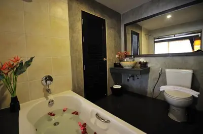 a bathroom with a bath tub and a toilet at Siralanna Hotel in Patong Beach