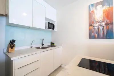 a kitchen with a sink and a painting on the wall at Private sea view apartment with jacuzzi at Baycliff in Patong Beach