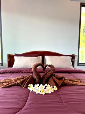 a bed with two towels and flowers in the shape of a heart at Smile Home Krabi Klong Moung Beach in Klong Muang Beach