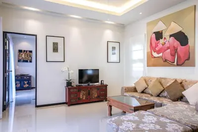 a living room with a couch and a tv at VILLA BUTON Private Pool Nai Harn beach in Nai Harn Beach
