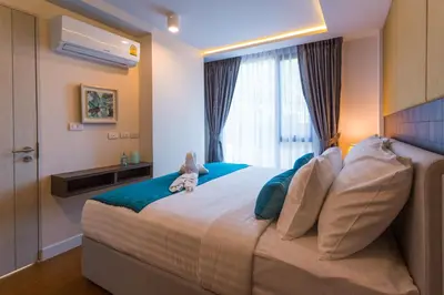a bedroom with a large bed with a teddy bear sitting on it at The Aristo by Holy Cow, 2-BR loft, 90 m2, pool view in Surin Beach