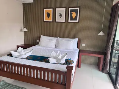 a bedroom with a bed with two white flowers on it at Chunut House Resort in Phi Phi Don