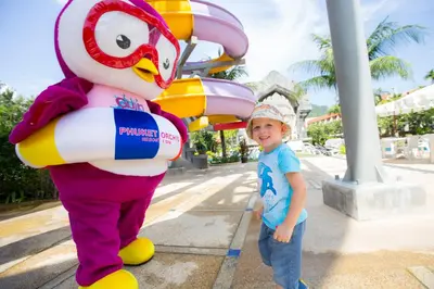 a young boy standing next to a chicken mascot at Phuket Orchid Resort and Spa in Karon Beach