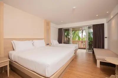 a bedroom with two beds and a balcony at Phuket Orchid Resort and Spa in Karon Beach