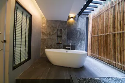 a bath tub in a bathroom with a large window at Baan Karon Resort in Karon Beach