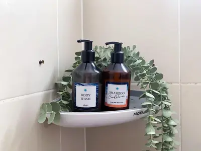 two bottles of wine sitting on a shelf in a bathroom at Turtle Rooms in Bang Tao Beach